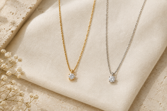 Illustrative gold-tone and silver-tone gemstone necklaces arranged side by side on ivory linen.