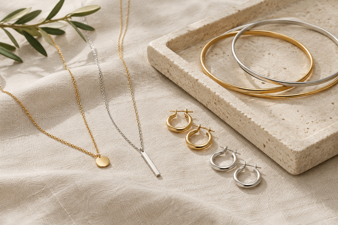 Illustrative arrangement of gold-tone and silver-tone necklaces, bracelets, and earrings on ivory linen.