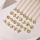 Personalized moissanite initial necklace featuring gold-plated bubble letters on a geometric background.