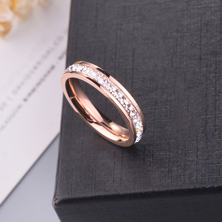 Minimal Titanium Rings For Women featuring a rose gold band with sparkling crystals on a black background.