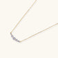 Delicate 14K gold-plated necklace with five graduated zirconia stones arranged in a curved arc on fine chain