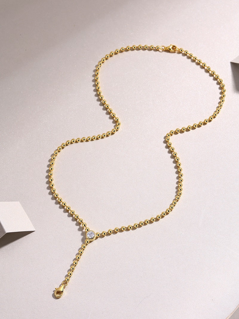 0.5 carat moissanite necklace for women on a gold chain with sparkling pendant.