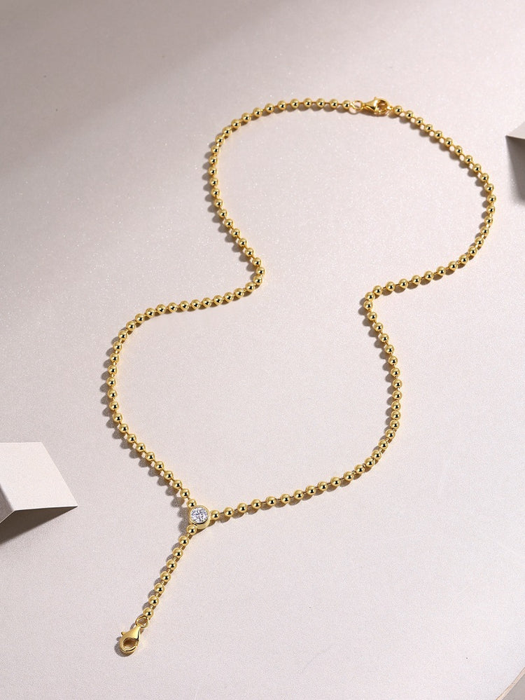0.5 carat moissanite necklace for women on a gold chain with sparkling pendant.