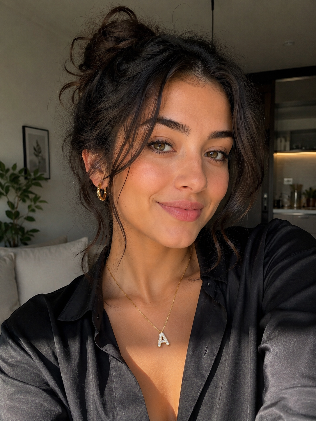 Personalized moissanite initial necklace showcased on a model wearing a black shirt, smiling with natural makeup.