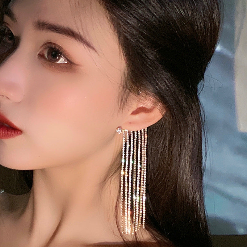 Luxe Drop Tassel Earring worn by a woman, showcasing a luxurious design with geometric tassels and a glamorous finish.