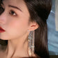 Luxe Drop Tassel Earring worn by a woman, showcasing a luxurious design with geometric tassels and a glamorous finish.