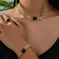 Luxury jewelry gift card featuring a stylish gold chain necklace, bracelet, and ring with black accents.