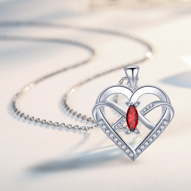 Infinity butterfly heart necklace with red stone and sparkling details on a silver chain, elegant jewelry gift for women.